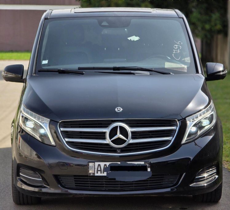 Un monospace noir de la marque Mercedes-Benz avec des phares éclairés.